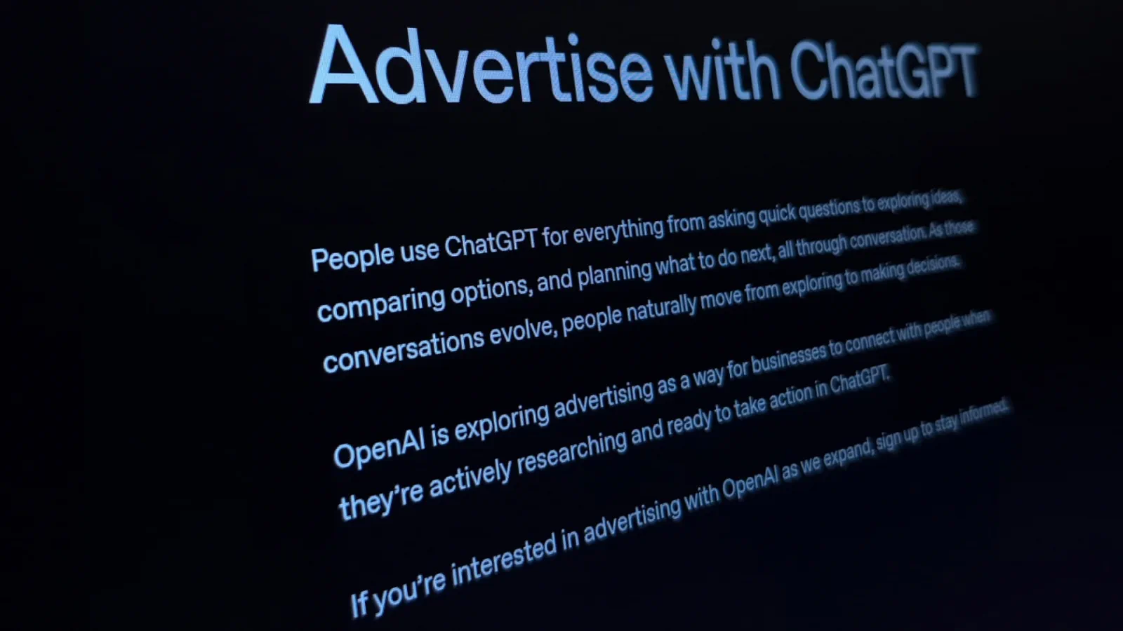 Close-up angled photograph of a monitor showing OpenAI's Advertise with ChatGPT page, the announcement that businesses can reach people while they research in ChatGPT, the new ad channel dental implant practices can apply for