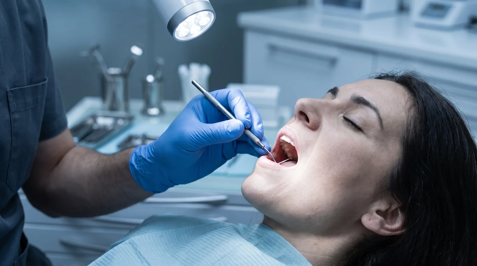 Periodontist examining a patient's gums with a probe during a second-opinion consultation, bright clinic light